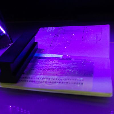 An ID document is viewed with UV lamp
